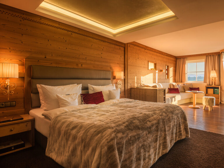 Die Kuschel-Suite mit großem Bett und warmen Holzwände, sowie direkten Zugang zum SPA-Garten im Wellnesshotel Oswald.