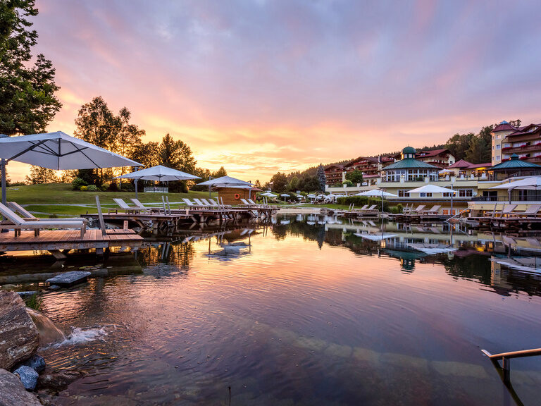 Der idyllische Naturbadesee bei Sonnenuntergang im Wellnesshotel Mooshof in Bodenmais.
