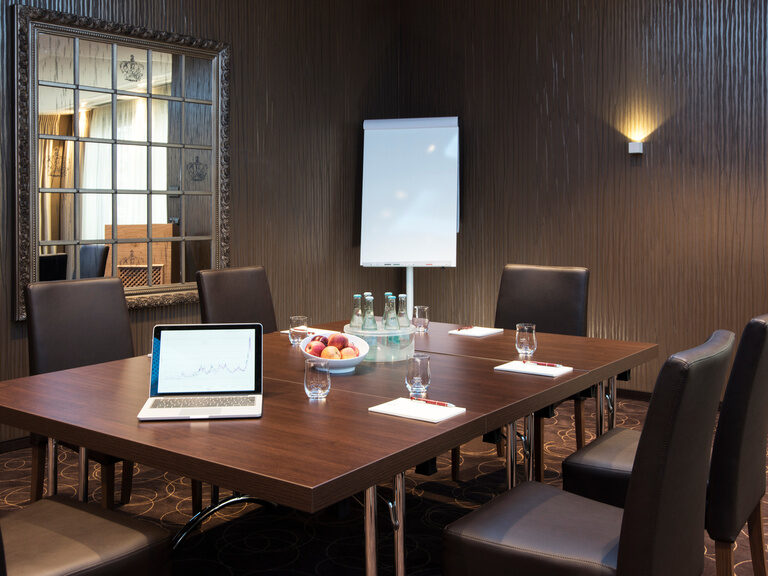 Kleinerer Abschnitt als Konferenzraum in der Event-Lounge mit edlem Holztisch und moderner Ausstattung im Hotel Oswald.